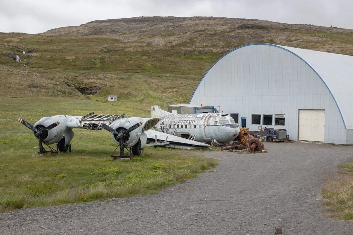 Épaves d'avions militaires anciens devant un hangar