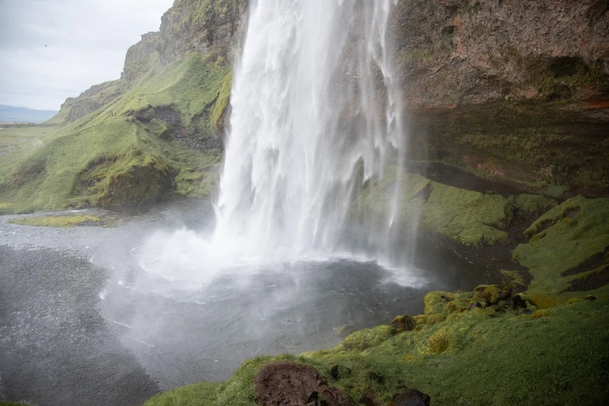 Puissante cascade tombant d'une falaise recouverte de mousse verte