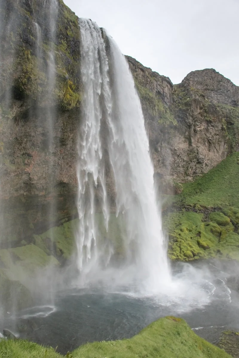 Grande cascade tombant d'une falaise rocheuse couverte de mousse