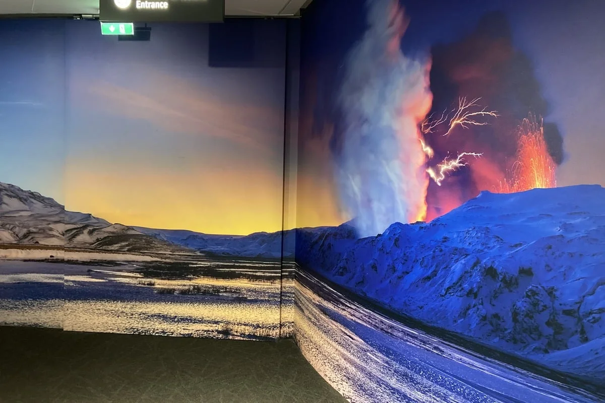 Entrée d'une exposition avec grandes fresques murales paysages volcaniques