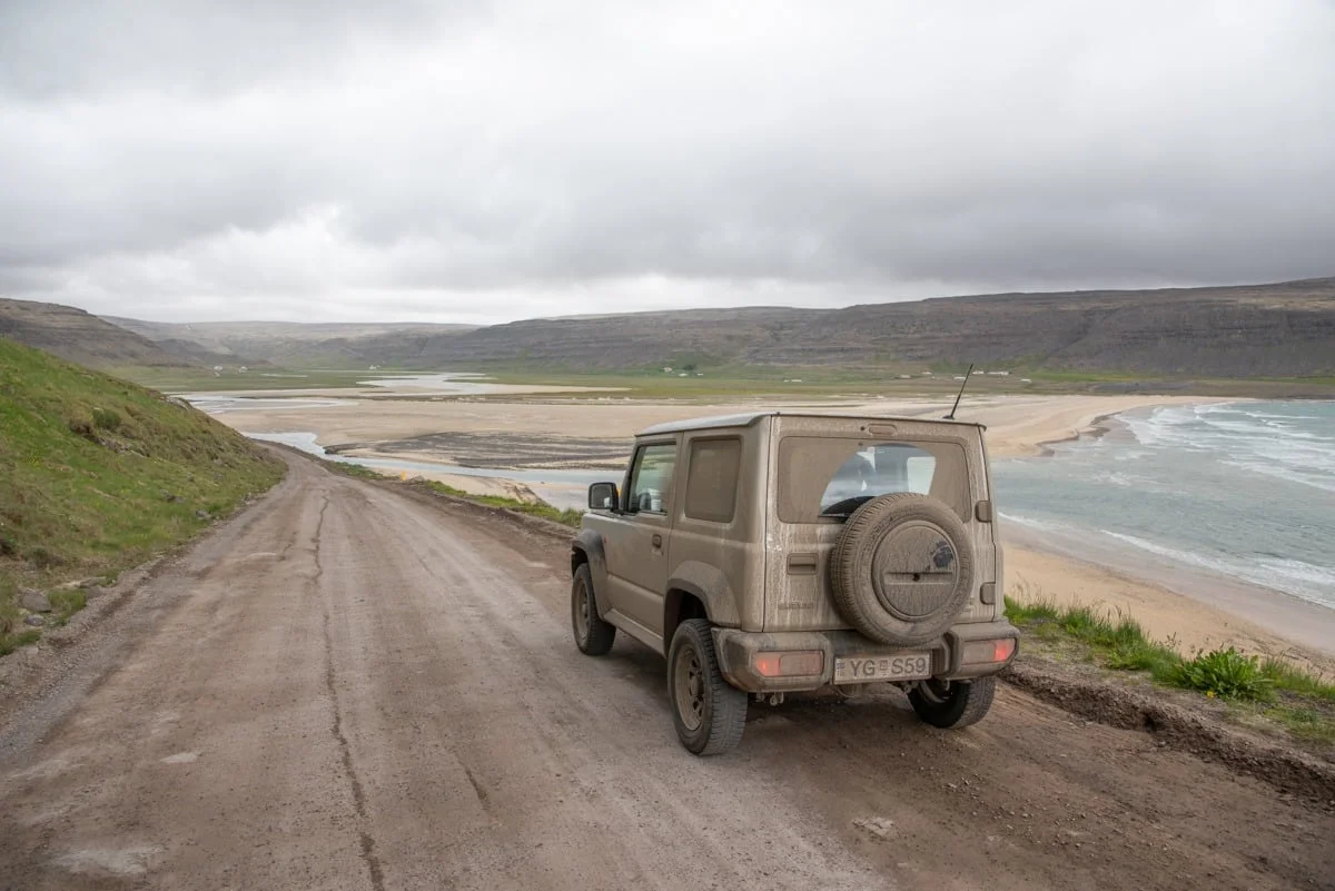 4x4 Suzuki Jimny sur piste de terre longeant une plage sauvage