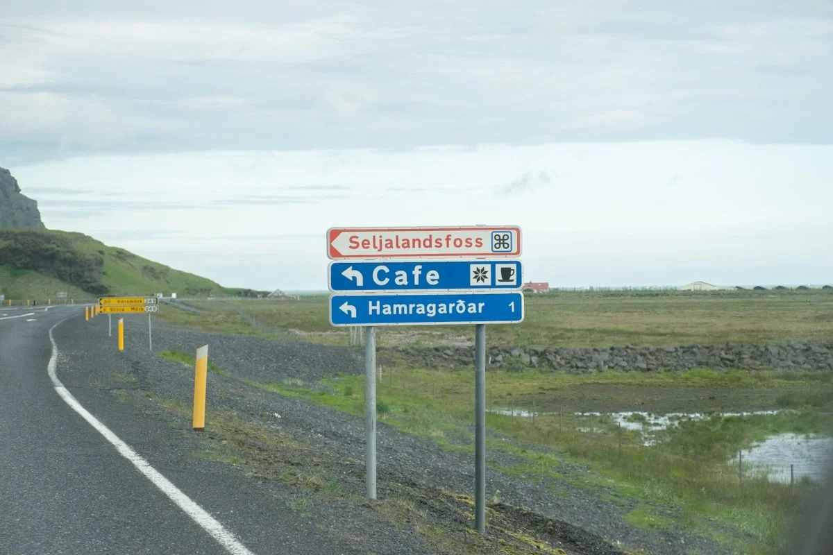 Panneaux de signalisation au bord d'une route, dont celui de Seljandsfoss