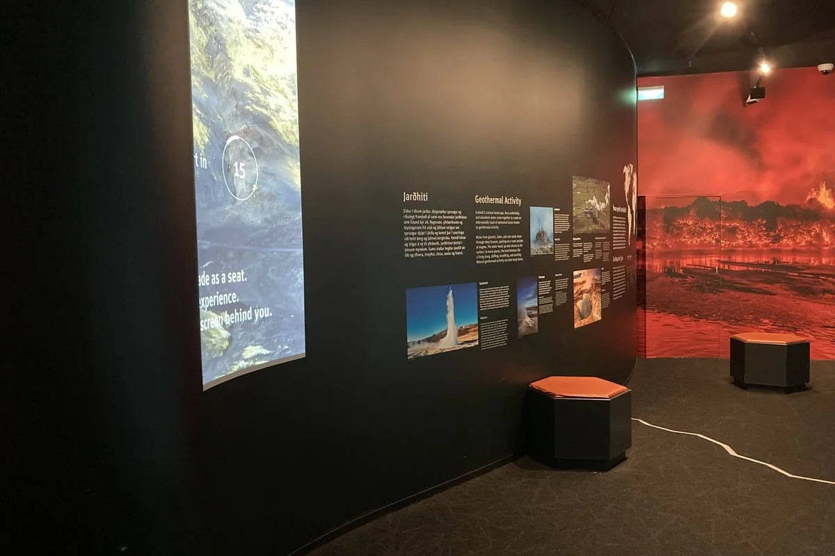 Salle d'exposition avec panneaux sur la géothermie et projection volcanique