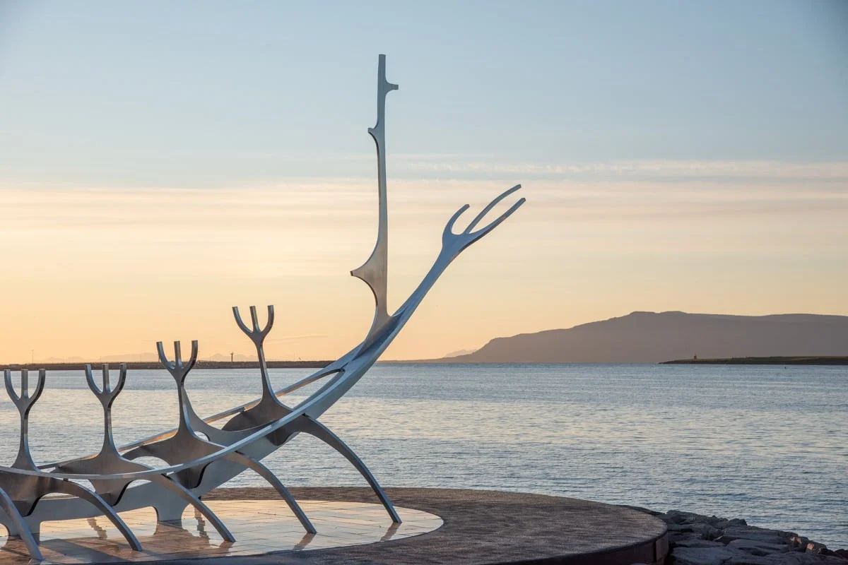 Sculpture métallique face à la mer au coucher du soleil