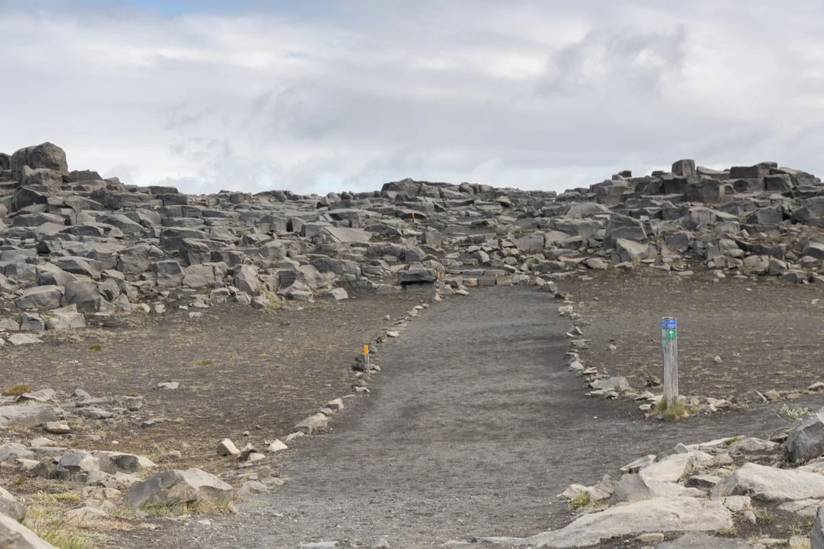 Sentier balisé traversant un champ de rochers volcaniques