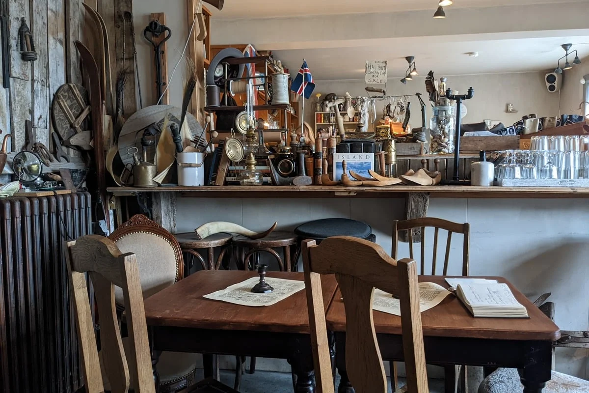 Intérieur de café rempli d'objets anciens et de chaises en bois
