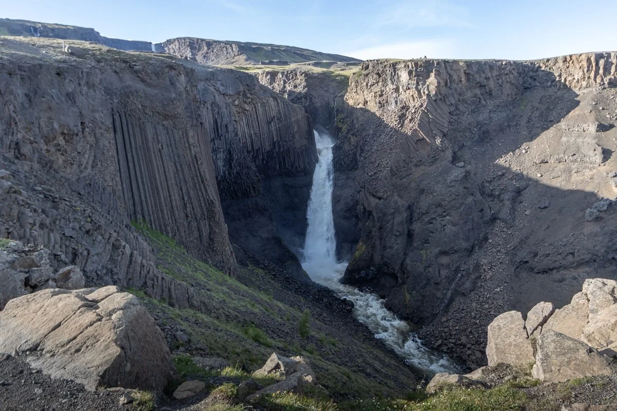 Cascade puissante dans un canyon de colonnes basaltiques sombres