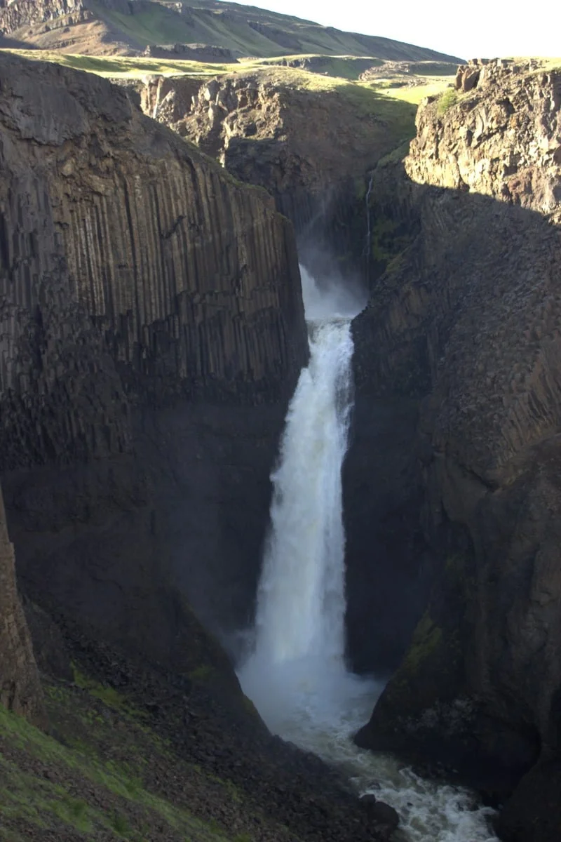 Cascade puissante chutant entre des falaises de basalte sombre