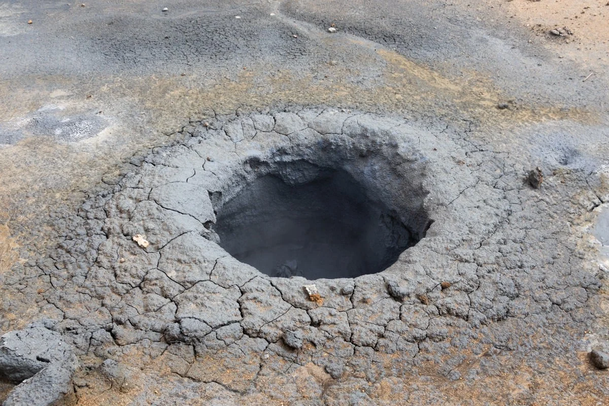 Cratère de boue volcanique séchée avec sol craquelé gris