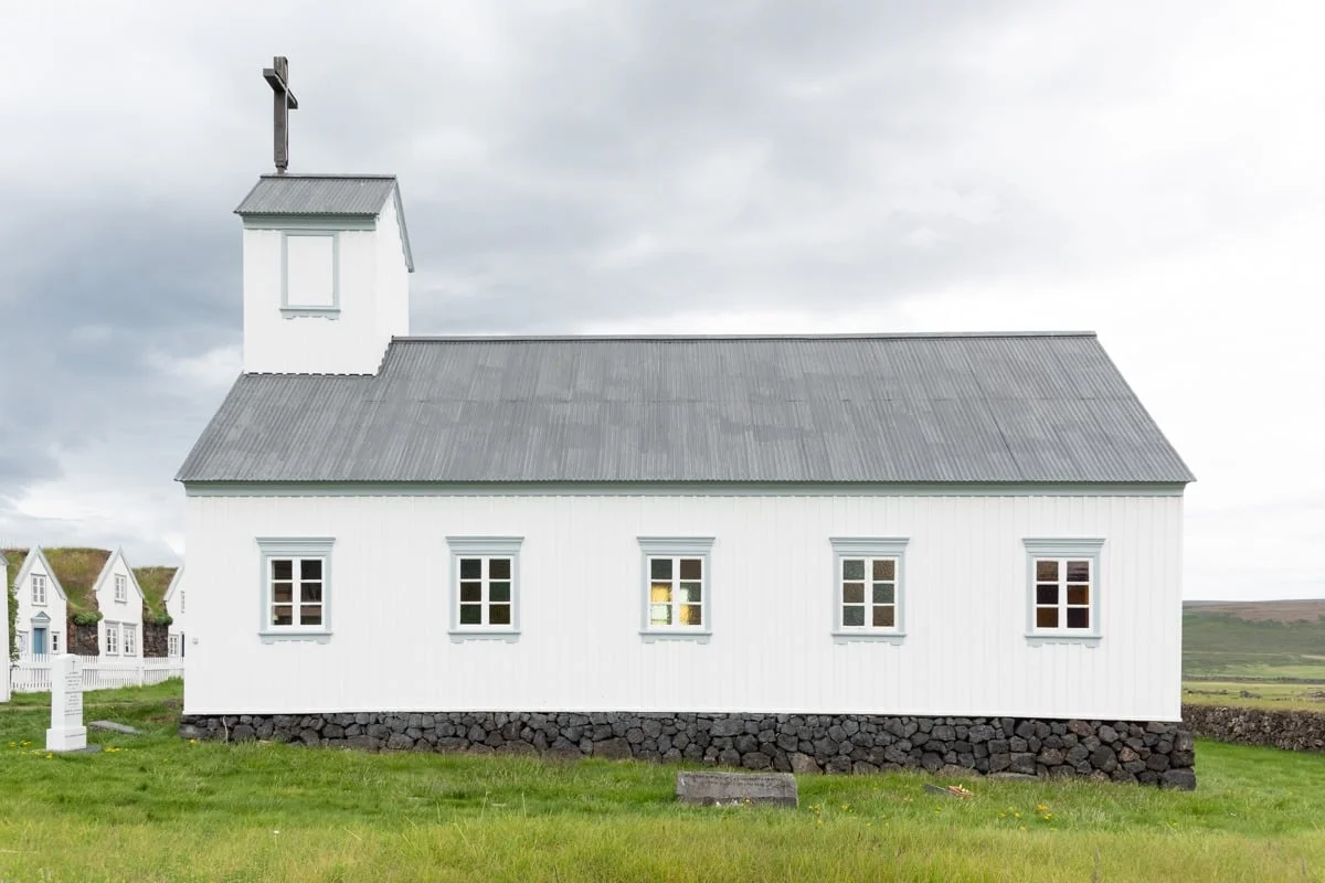 Petite église blanche avec toit en tôle grise et croix