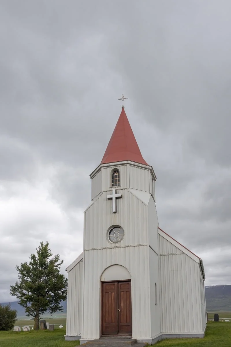 Petite église blanche à toit rouge et clocher