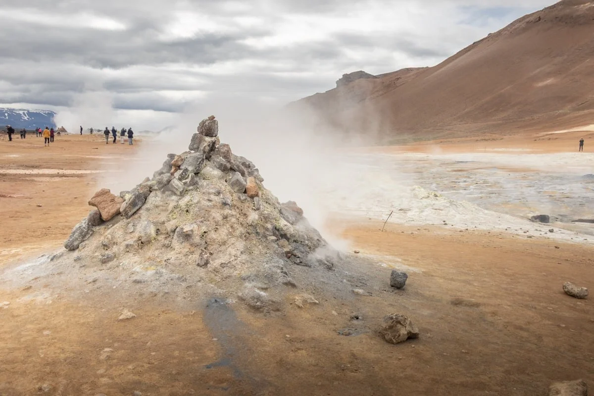 Fumarole crachant de la vapeur sur un sol volcanique ocre