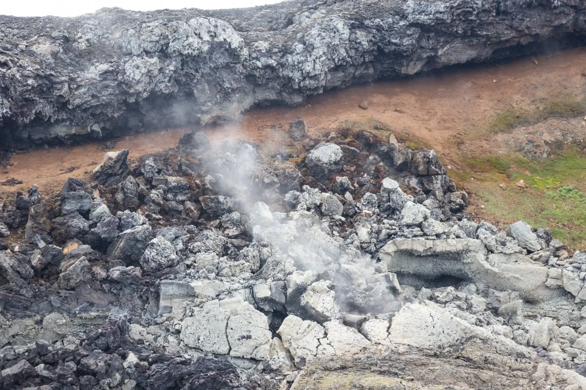 Fumée s'échappant de roches volcaniques noires et grises