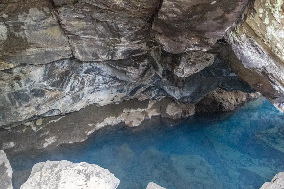 Piscine d'eau bleue turquoise au fond d'une grotte rocheuse
