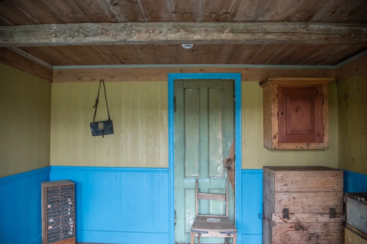 Intérieur rustique avec porte verte encadrée de bleu et mobilier en bois