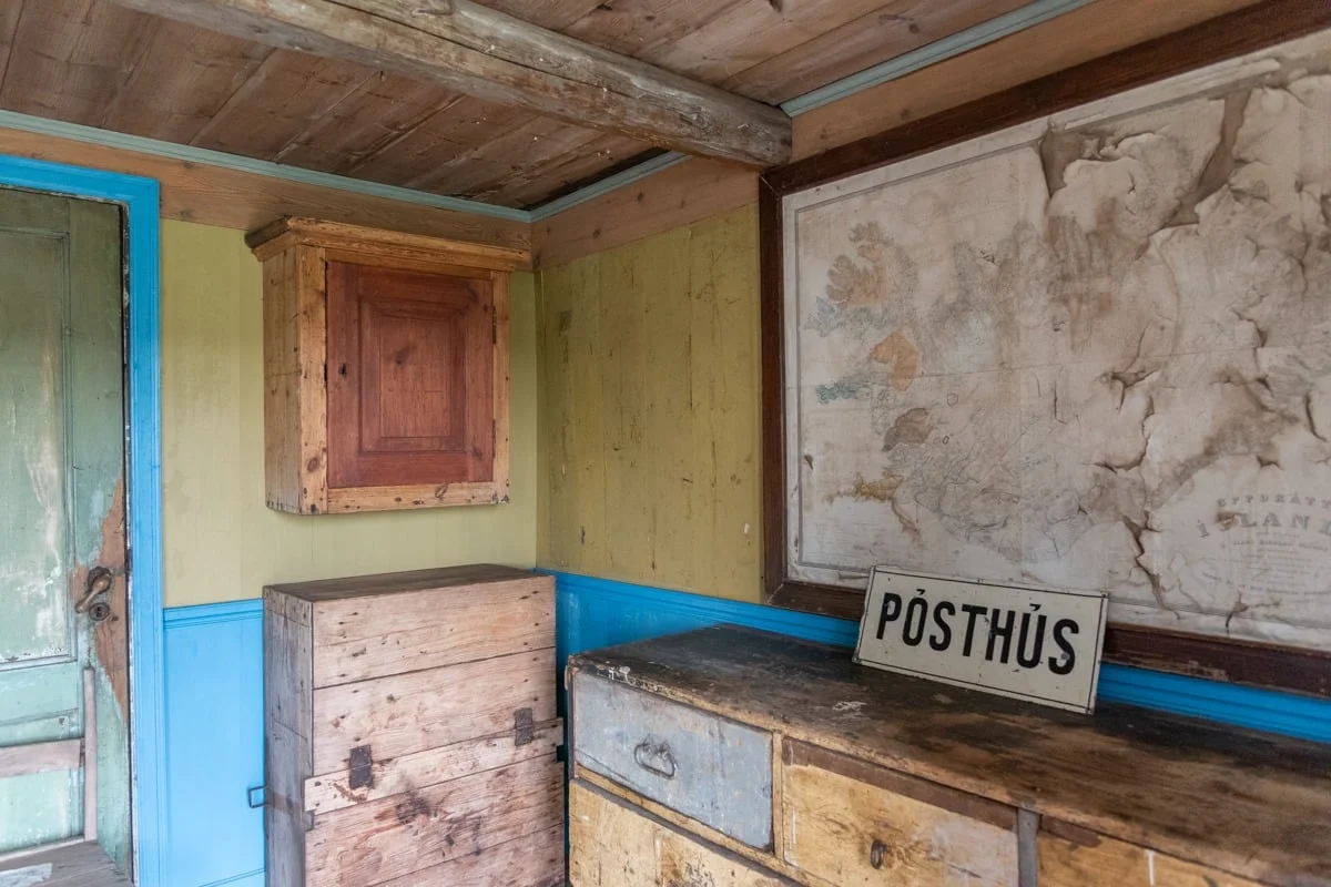 Intérieur rustique d'un ancien bureau de poste avec meubles en bois et carte murale