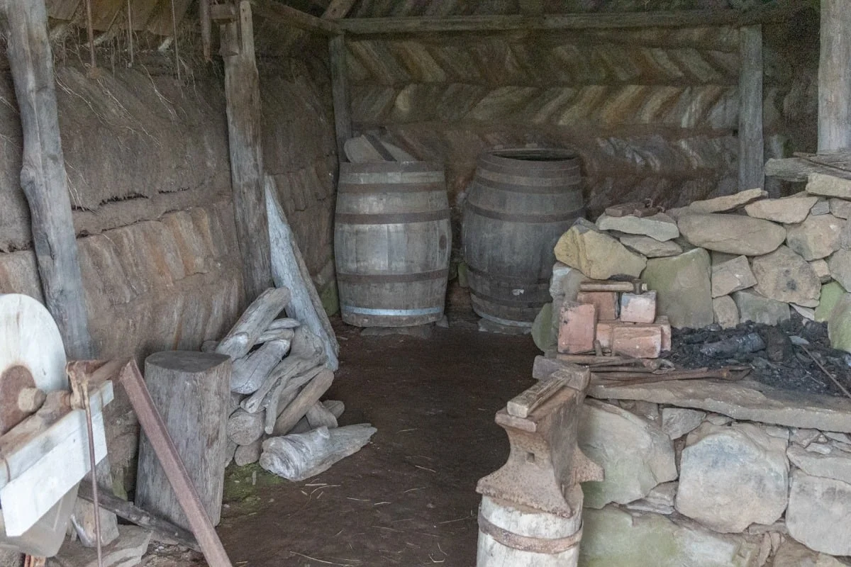 Intérieur d'une grange ancienne avec tonneaux en bois et pierres