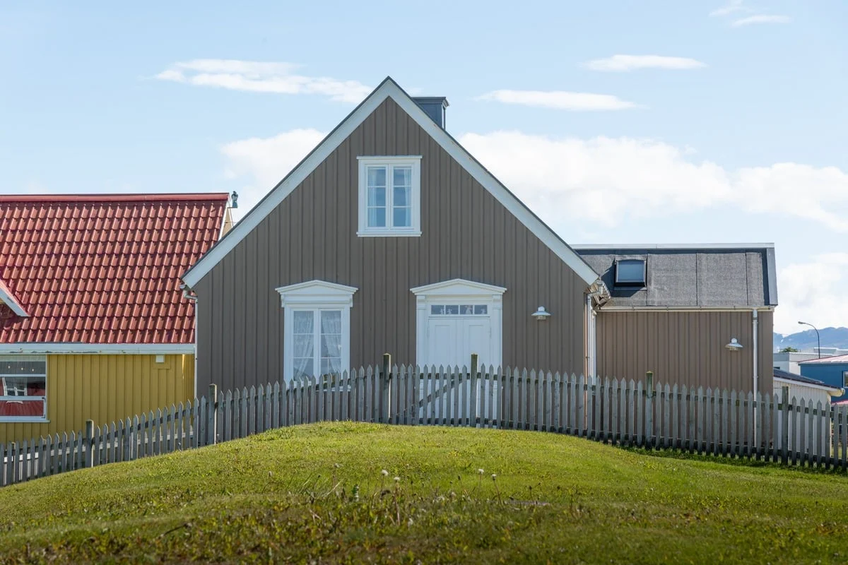 Maison en bois gris avec clôture blanche