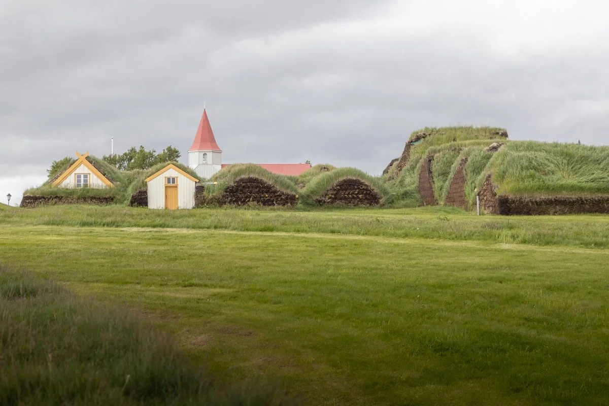 Maisons en tourbe recouvertes de gazon avec une église