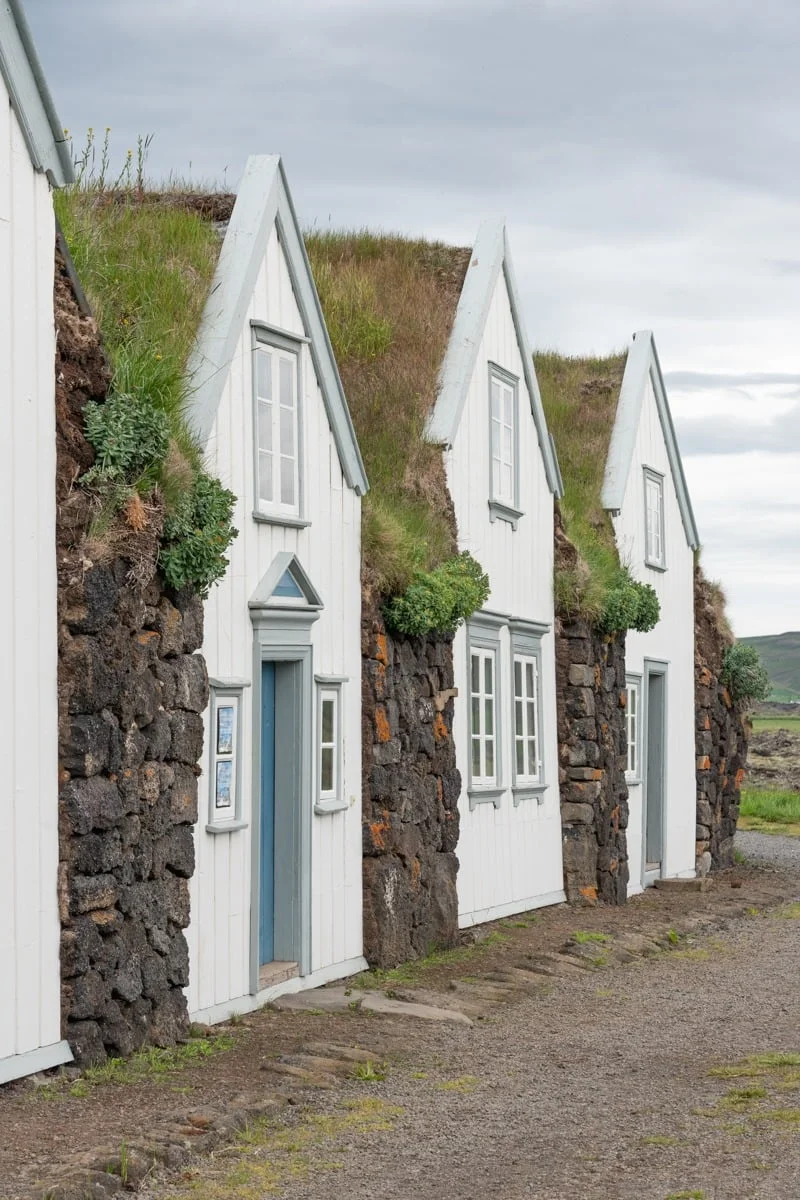 Rangée de maisons blanches traditionnelles avec toits en tourbe végétalisés