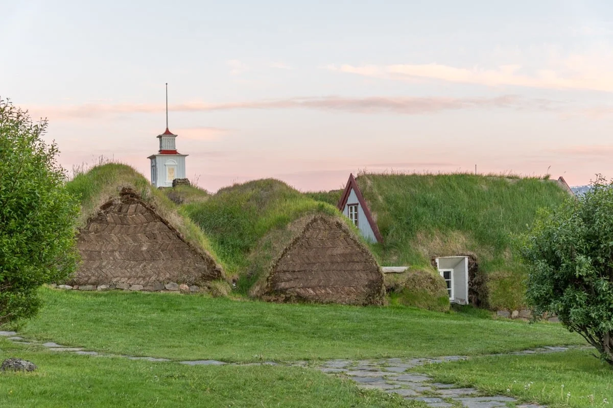 Maisons traditionnelles en tourbe avec toits enherbés au crépuscule rosé