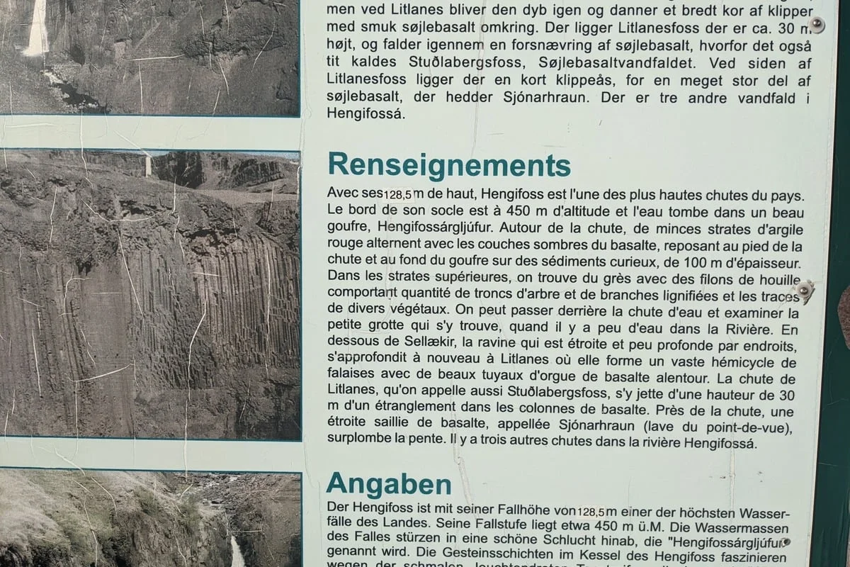 Panneau d'information touristique multilingue sur une cascade volcanique