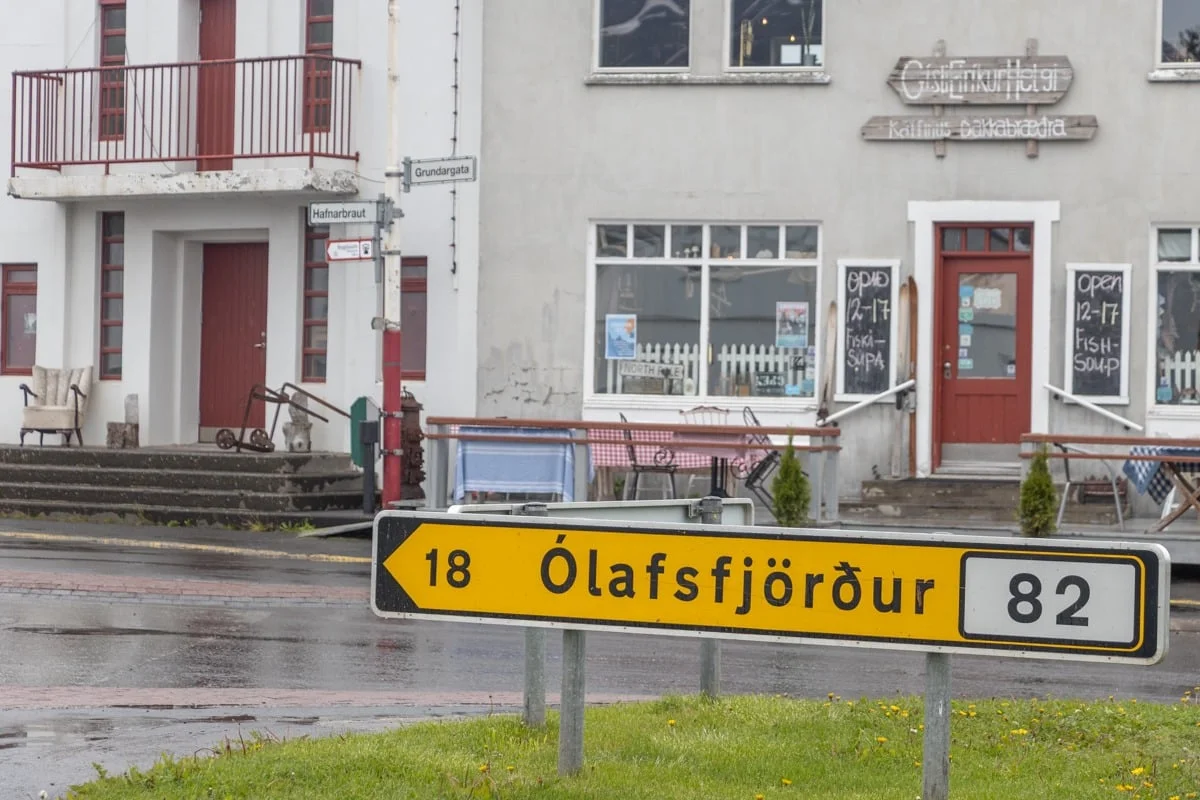 Panneau routier jaune devant une bâtisse