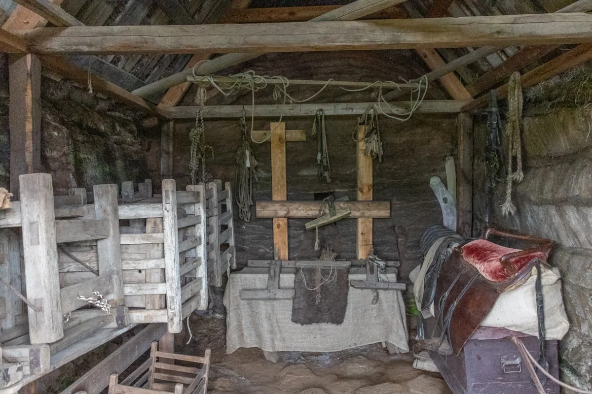 Intérieur d'une remise rustique avec selles et équipements en bois