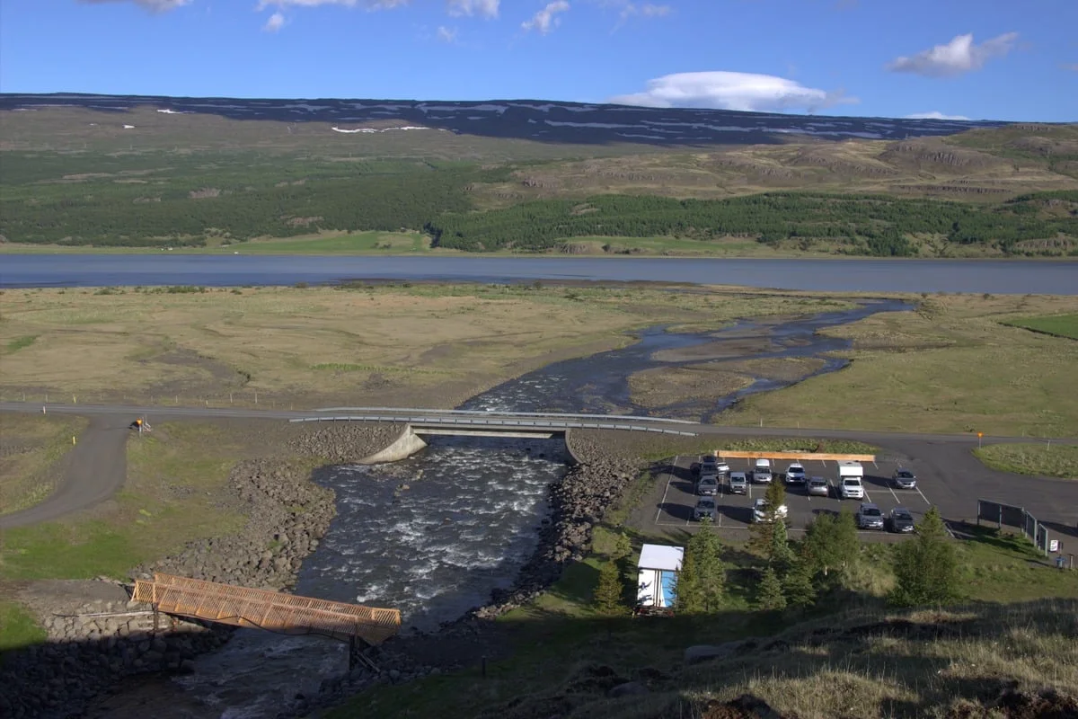 Vue aérienne d'une rivière traversant une vallée verdoyante avec pont routier