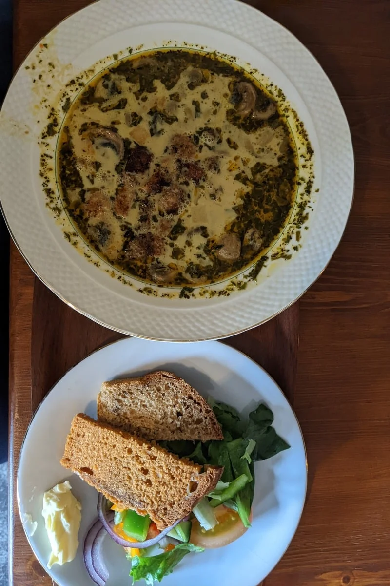 Soupe crémeuse aux champignons et sandwich garni sur table en bois