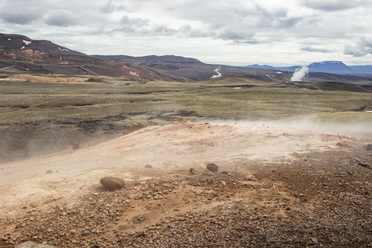 Zone géothermique avec fumerolles et sol ocre volcanique