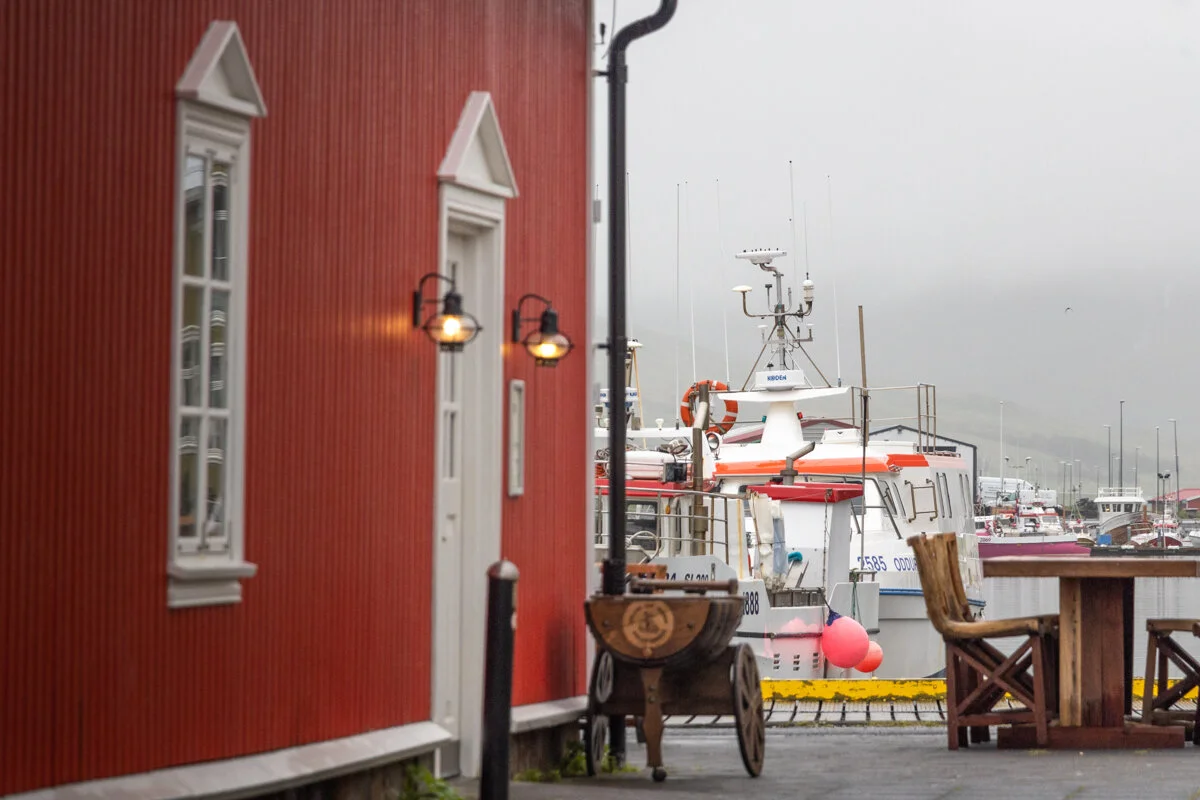 un bâtiment rouge avec des portes blanches près d'un port