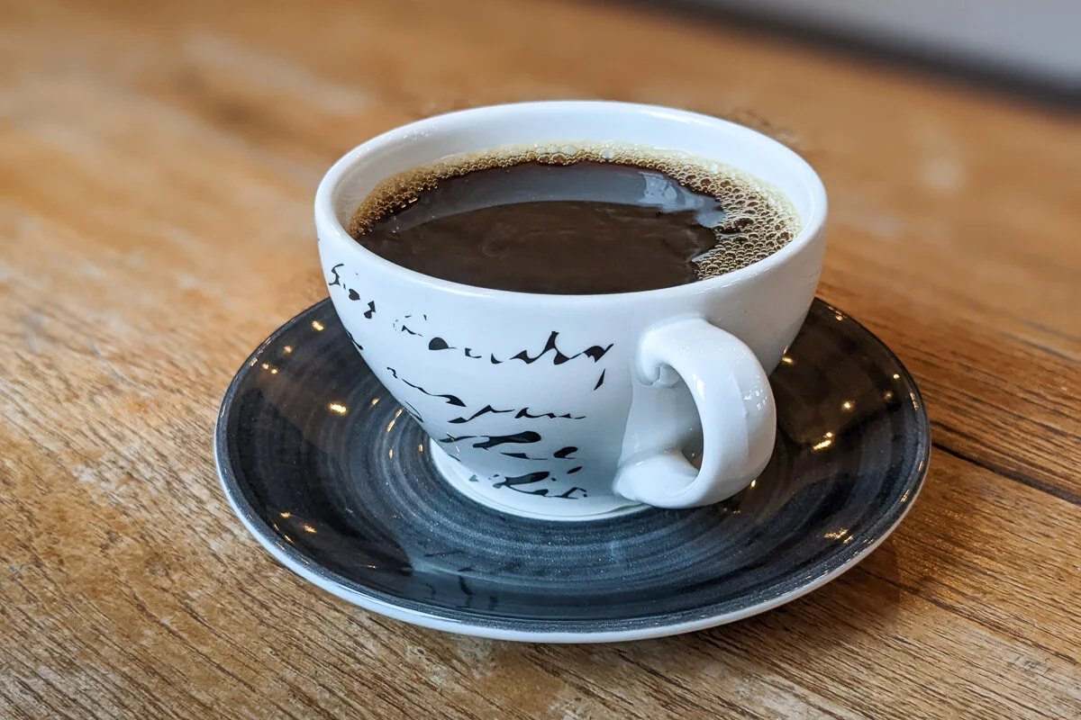 une tasse de café noir sur une soucoupe