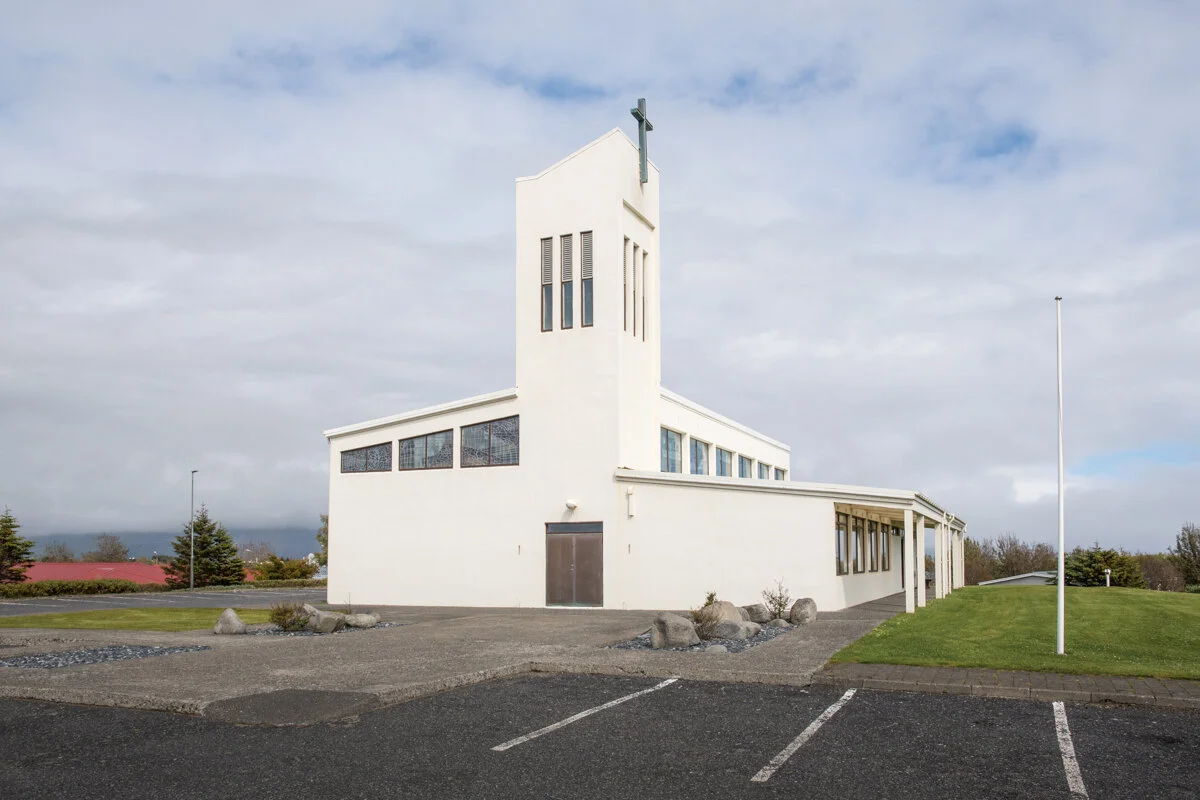 église moderne blanche avec clocher et parking