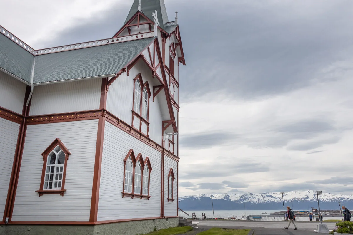 église blanche et rouge avec montagne en arrière-plan