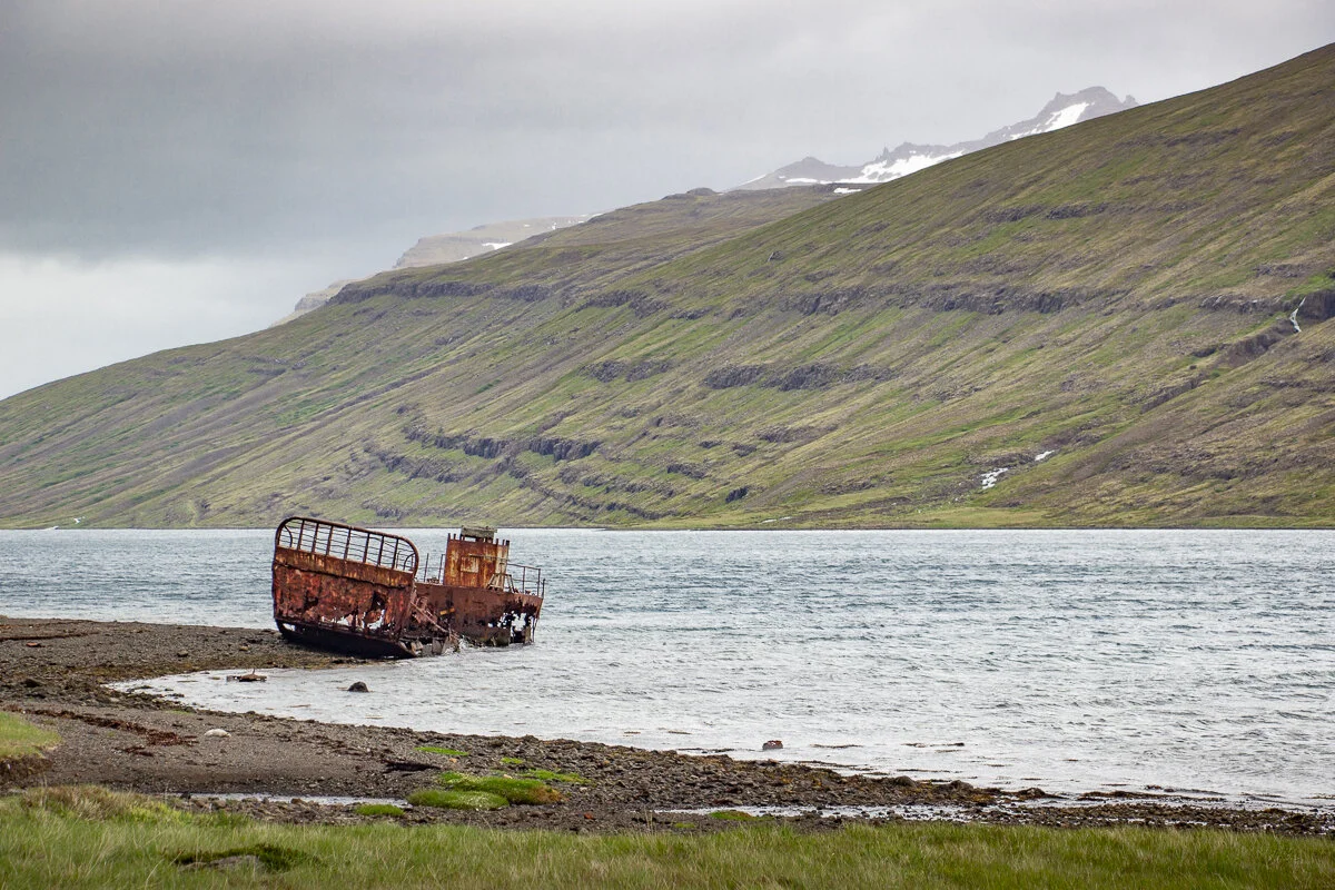 un bateau échoué au bord d'un fjord