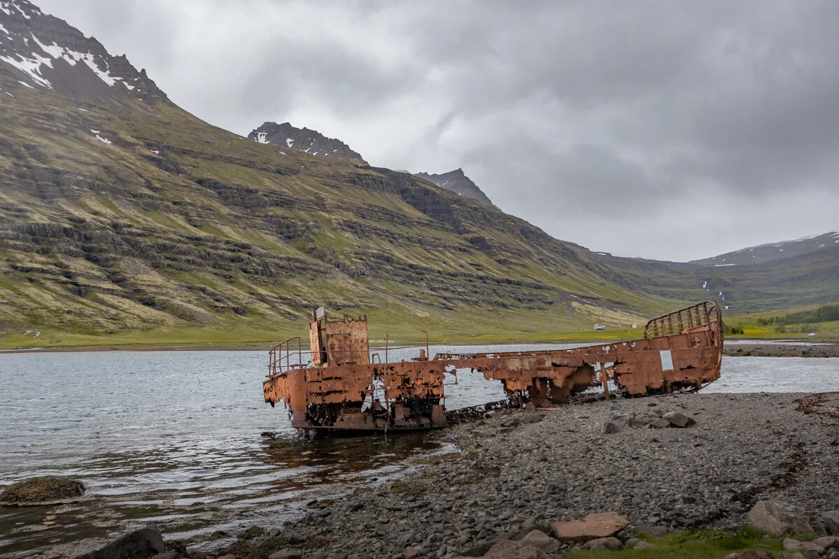 épave de bateau rouillé au bord d'un fjord