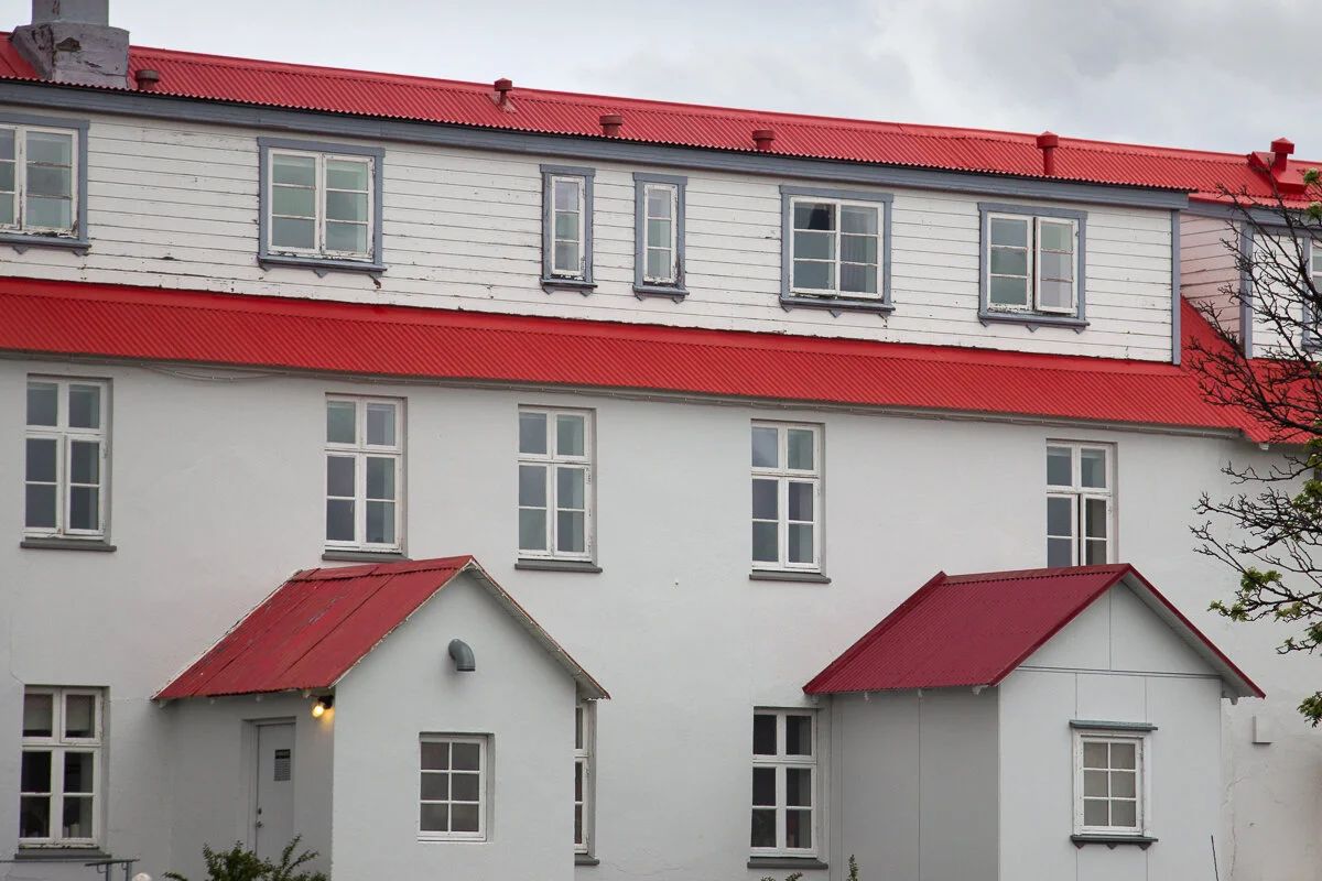 façade blanche d'un hôtel avec des toitures rouges