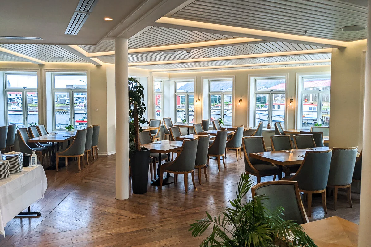 restaurant avec tables, chaises et baies vitrées