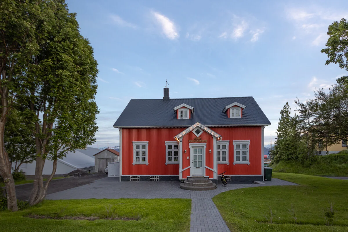 petite maison rouge avec une allée et une pelouse