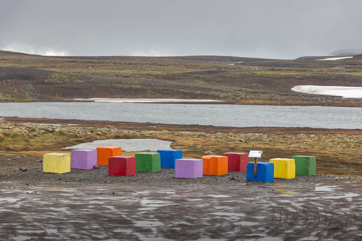 oeuvre d'art de conteneurs colorés alignés sur un terrain désert