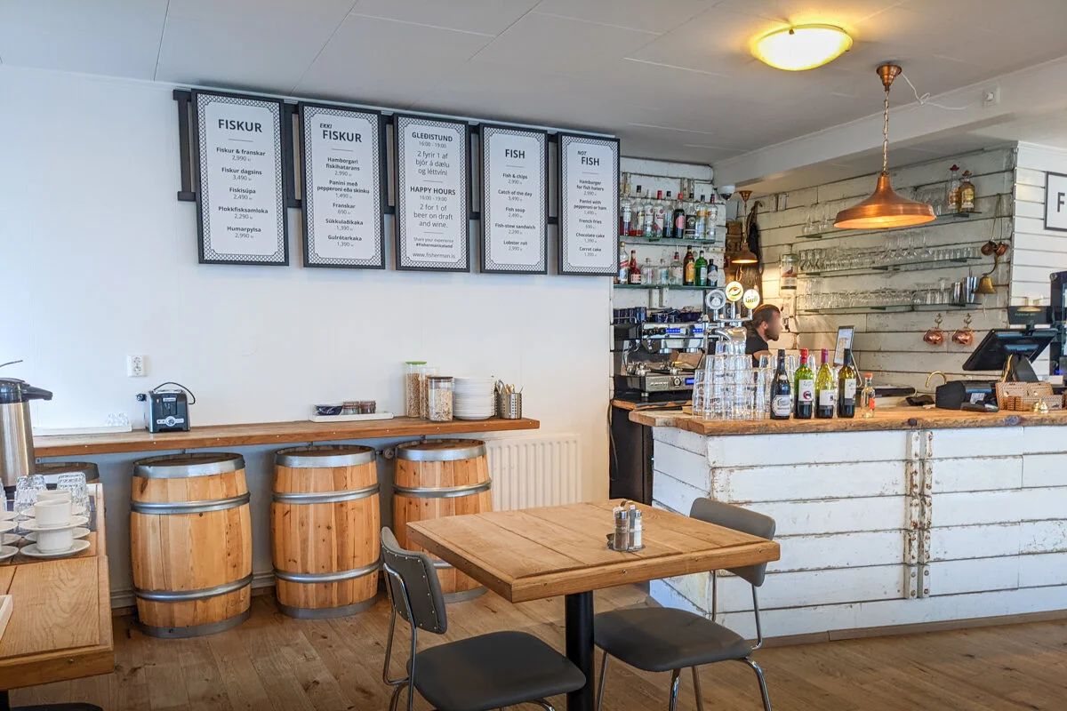 intérieur d'un café avec comptoir, tables et menu au mur