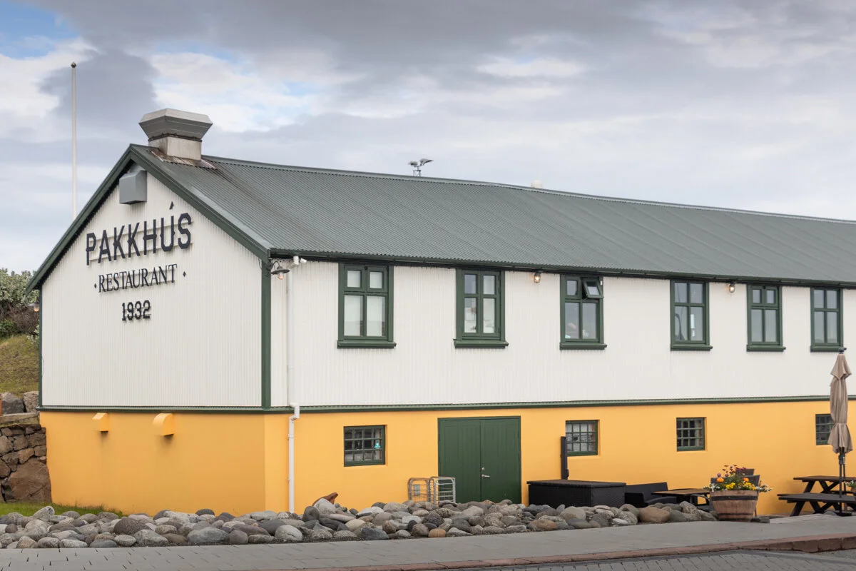 bâtiment blanc et jaune avec le nom "PAKKUS" inscrit sur la façade