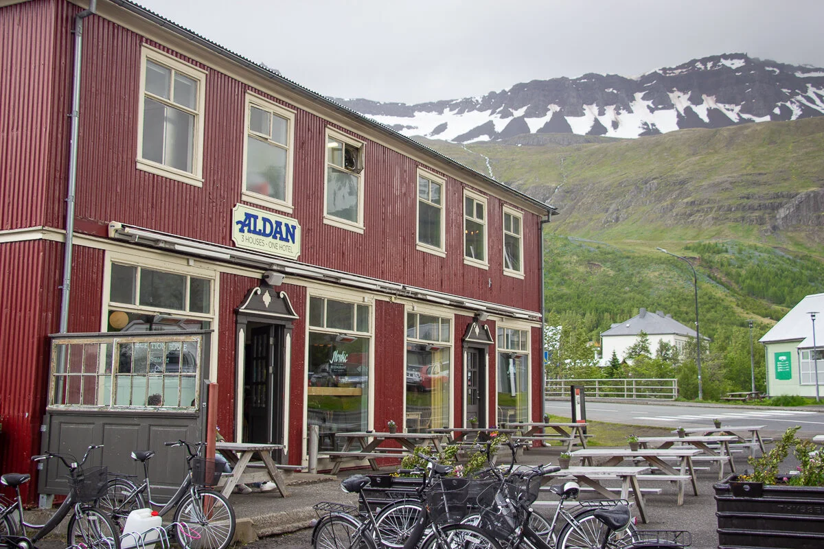 un bâtiment rouge avec des vélos garés devant et la montagne en arrière plan