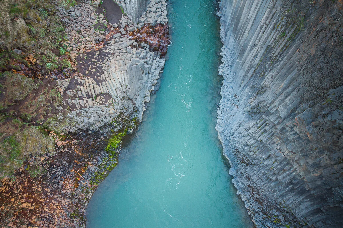 une rivière turquoise entre deux parois rocheuses, vue du dessus