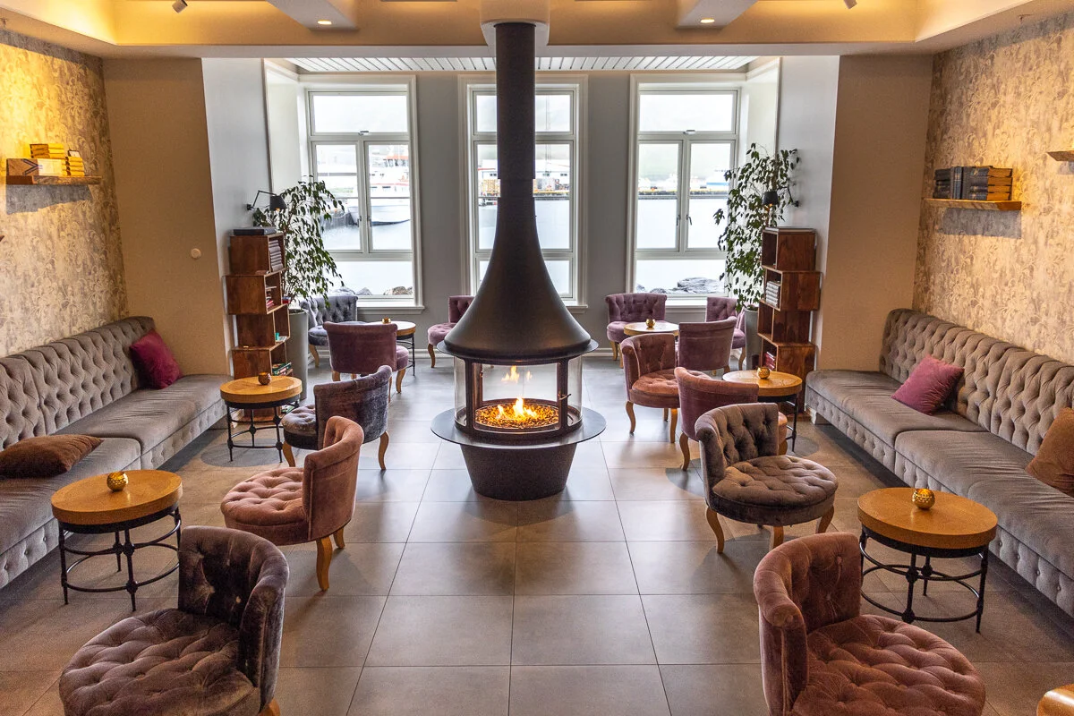 foyer avec cheminée suspendue centrale et sièges dans le lobby