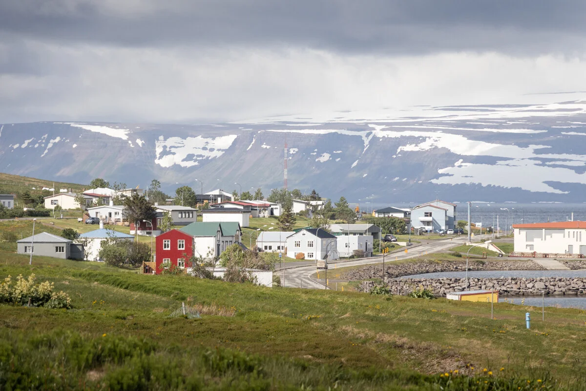 village de Sudavik avec maisons colorées au pied de montagnes enneigées