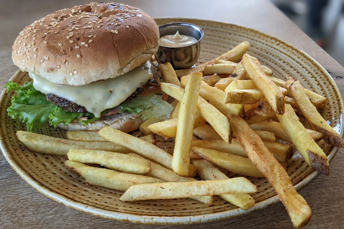 un hamburger avec et frites sur une assiette