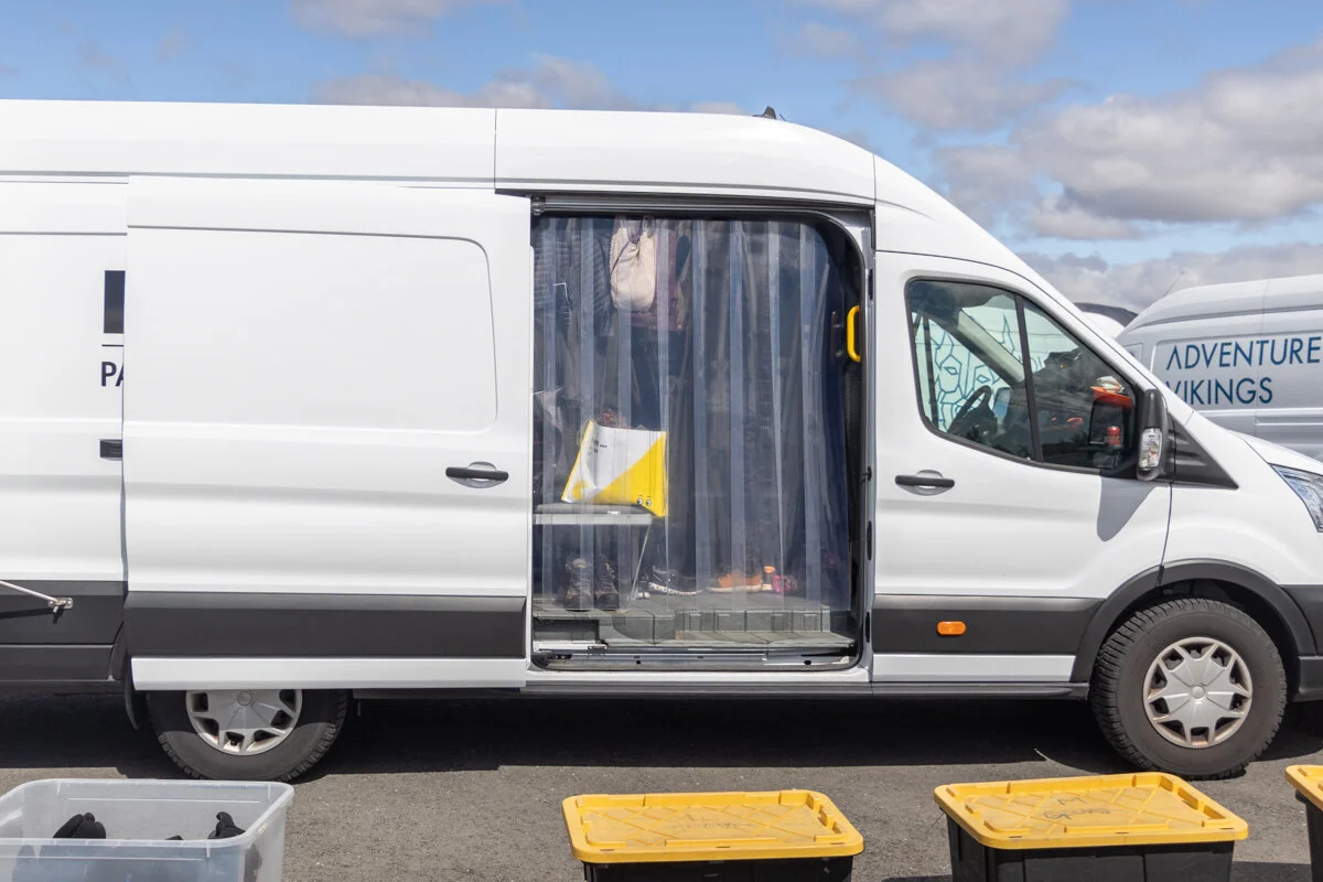 camionette blanche avec portes ouvertes et rideau gris