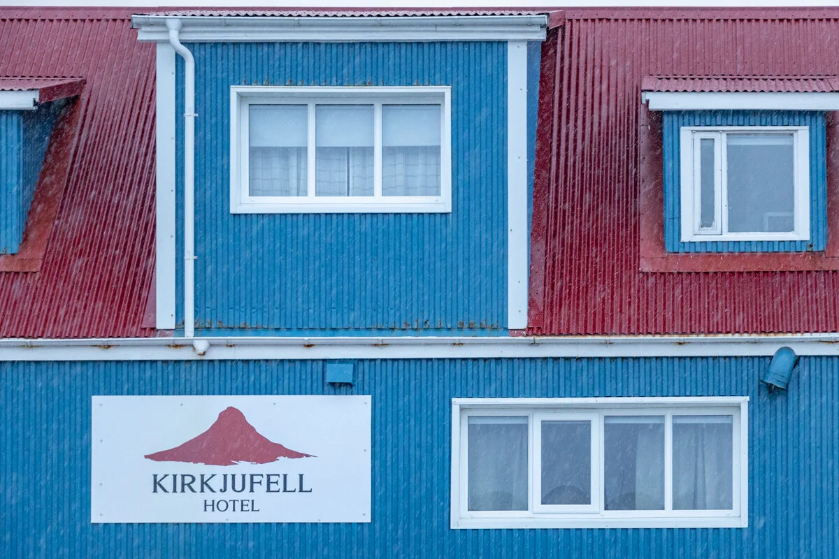 façade d'un bâtiment bleu et rouge de l'hôtel Kirkjufell et enseigne